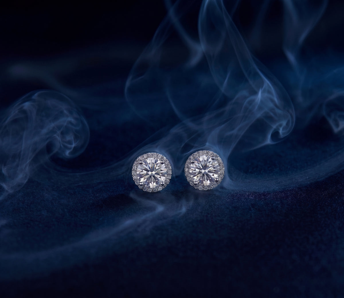 Corona halo studs, a pair of earrings with a round center stone surrounded by a ring of pavé stones.