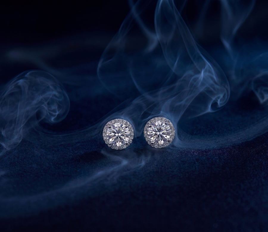 Corona halo studs, a pair of earrings with a round center stone surrounded by a ring of pavé stones.