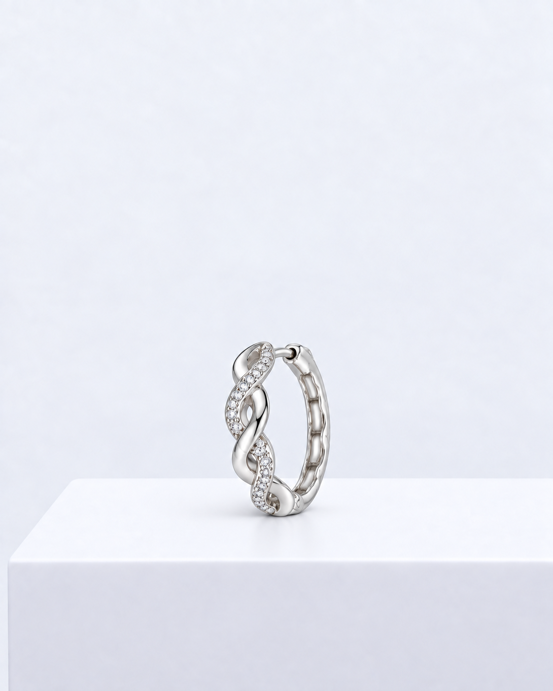 Elara twist hoop, a pavé-set huggie hoop earring with an infinity-style twist.