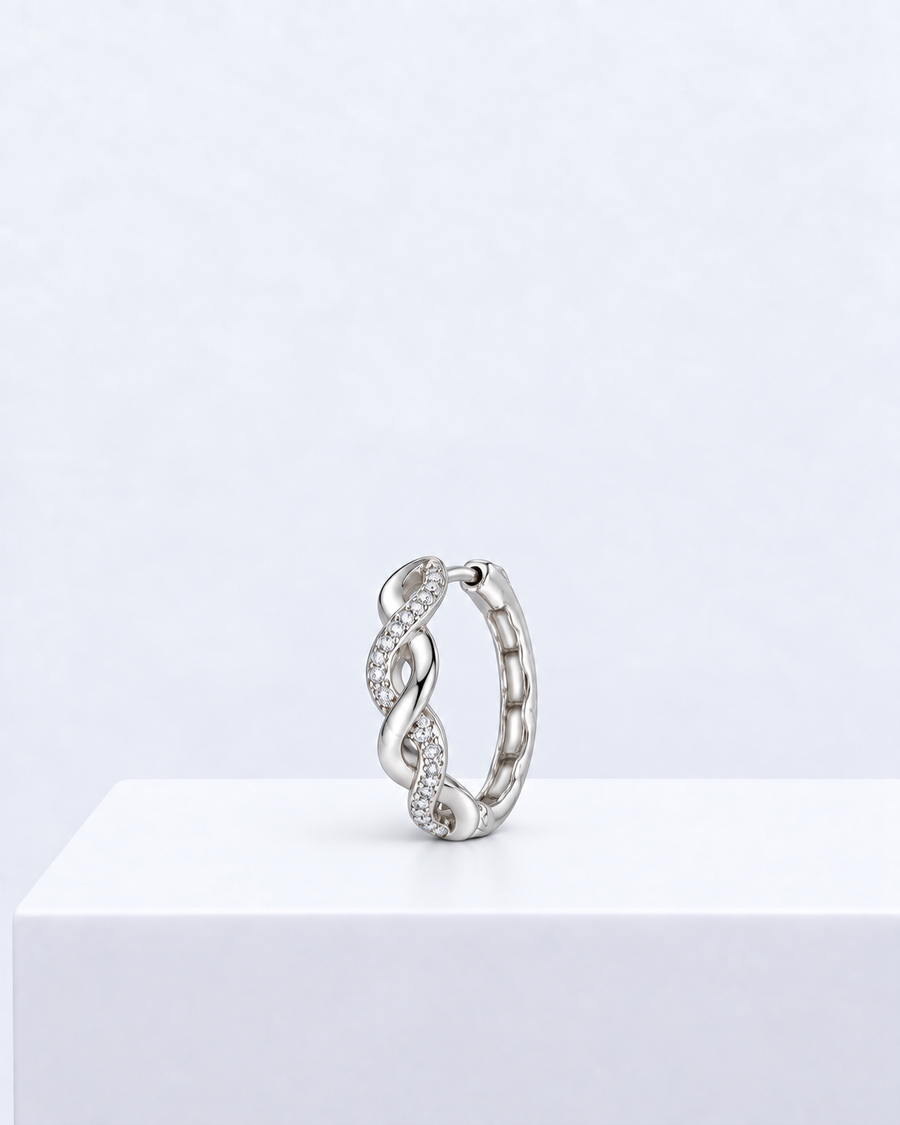 Elara twist hoop, a pavé-set huggie hoop earring with an infinity-style twist.