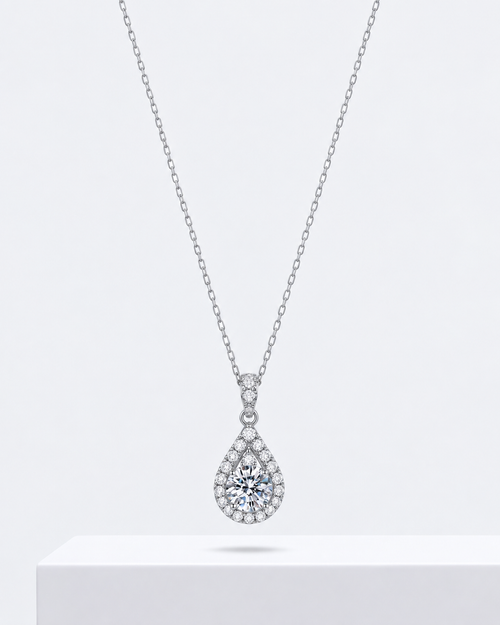 Amora heart pendant, an open heart necklace outlined in stones, on a fine chain.