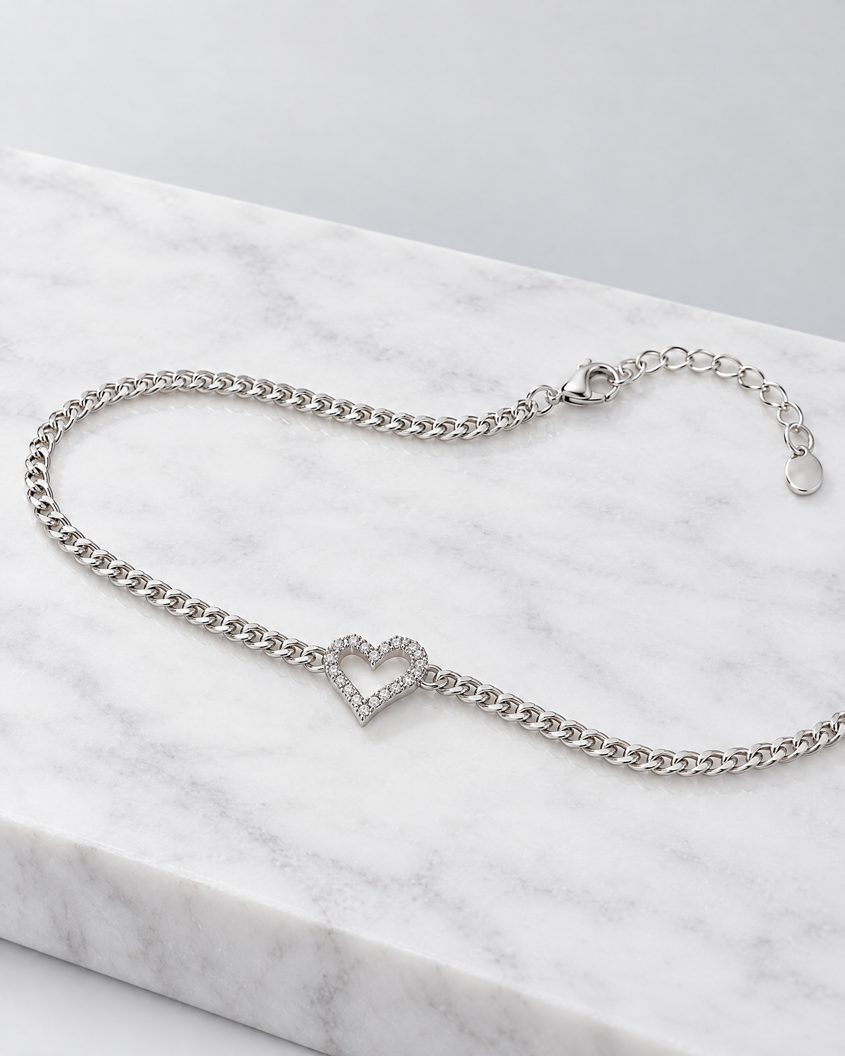 Colette heart bracelet laid out in a long line, showing the chain and clasp.
